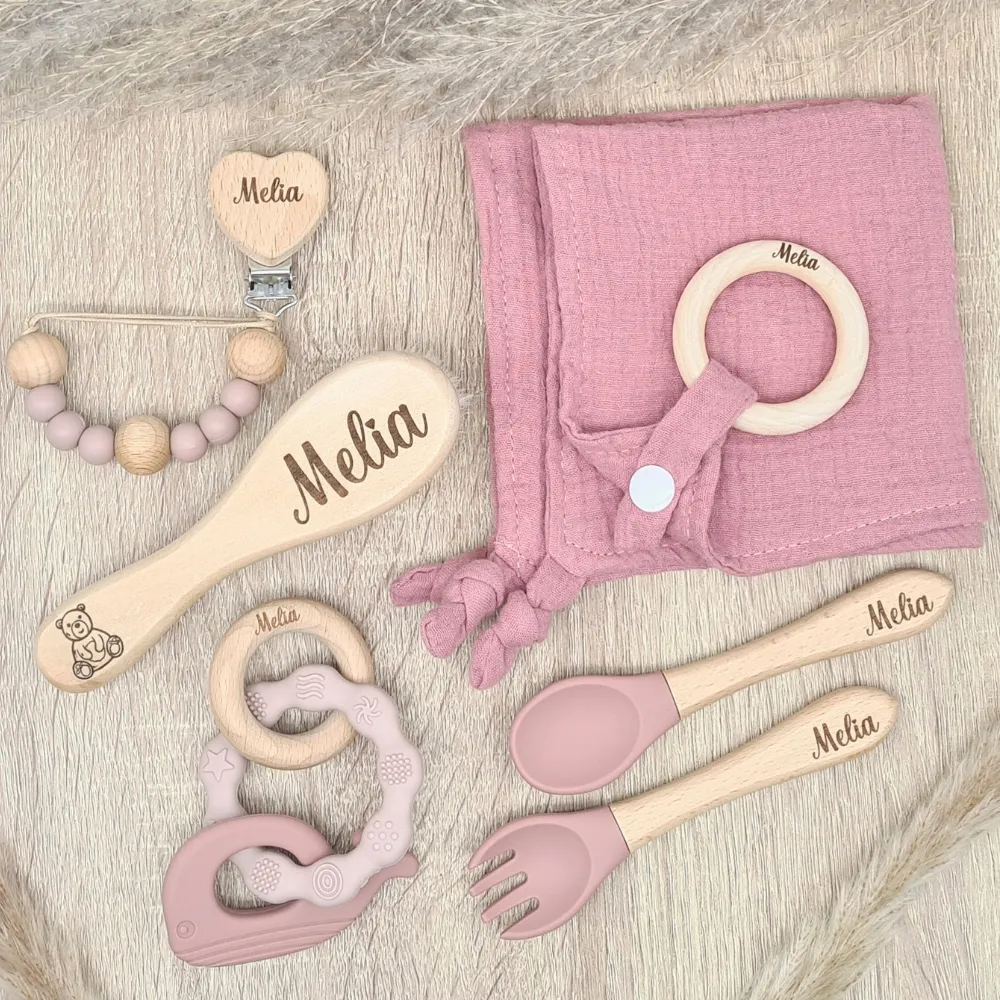 Coffret cadeau de naissance Melia avec attache tétine, couvert, anneau de dentition, peigne et doudou, couleurs rose et bois