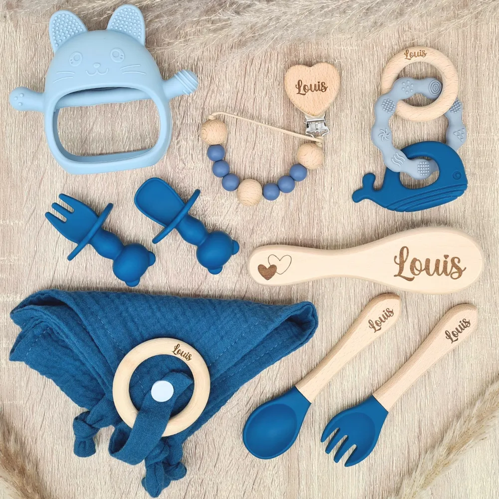 Coffret cadeau de naissance bleu avec jouets en silicone, ustensiles en bois et accessoires de puériculture personnalisés.