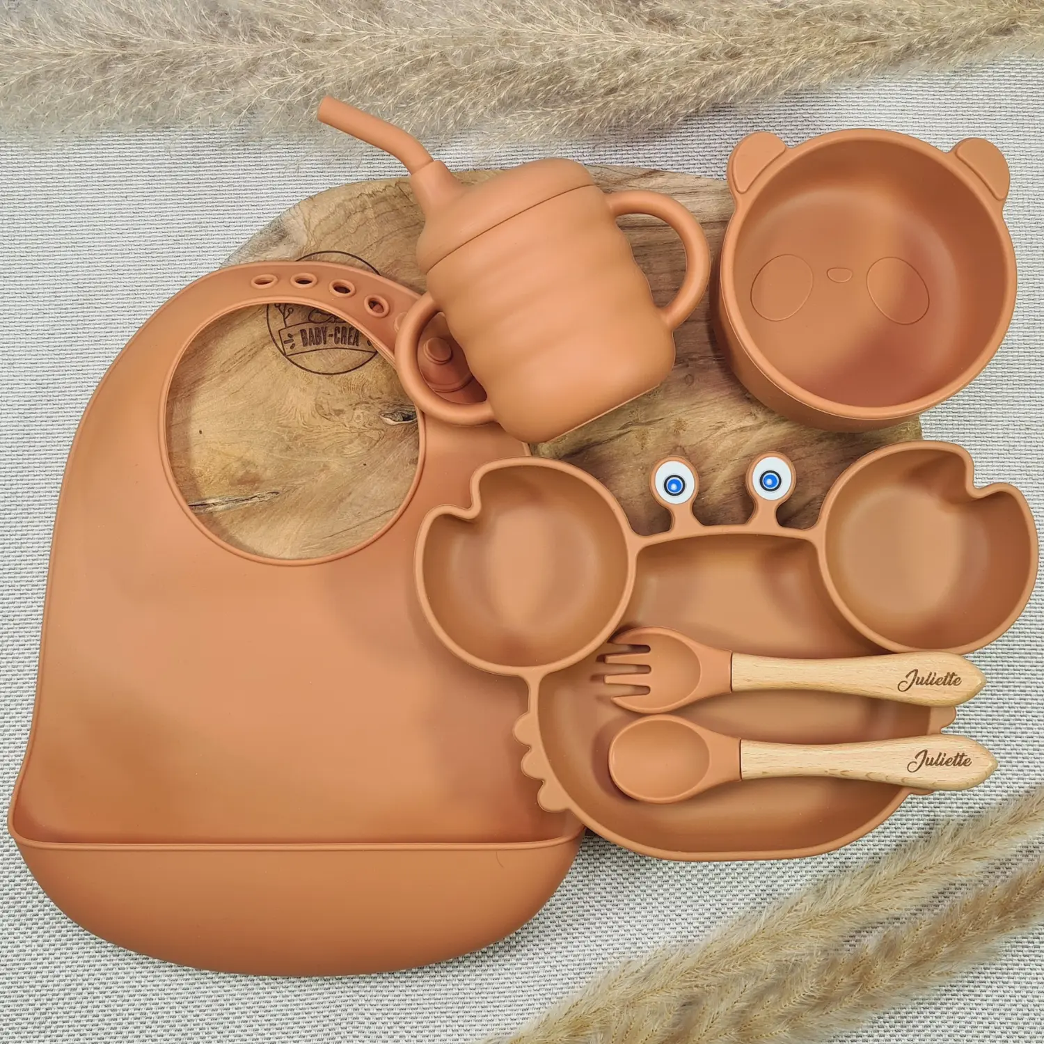 Coffret Naissance en Silicone Terracotta Coffret Naissance en silicone terracotta avec bavoir, assiette et tasse, conçu pour le plaisir des repas pour bébés.